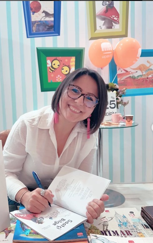 Hülya Biyan bir kitap imzalarken