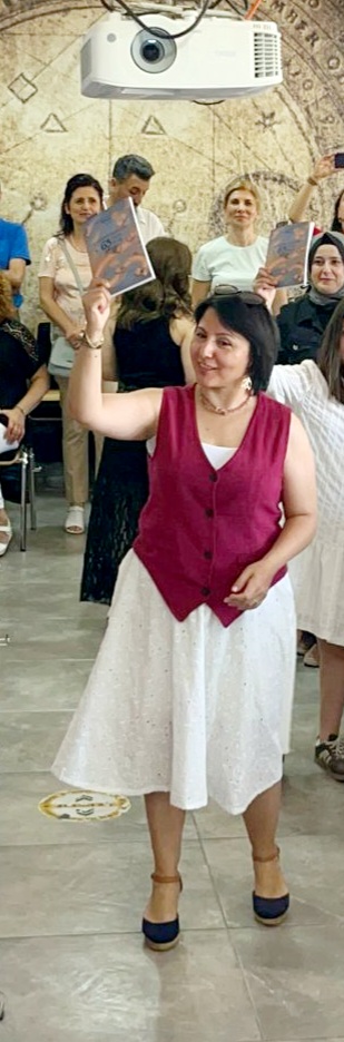 Hülya Biyan kitabı gururla havaya kaldırıyor